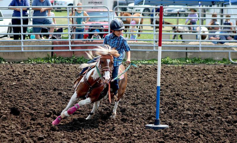 Vincent Stewart, 9, rides his horse Zuma around the poles during the exhibition poles competition at the Kendall County Fair on Thursday, Aug. 3.