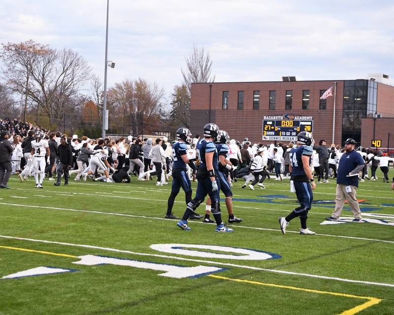 Fenwick fans storm the field at Nazareth Academy High School in La Grange Park as the football team stopped Nazareth Academy from making a two-point conversion during the 6A semifinals game in overtime on Saturday Nov. 22, 2025, held at Nazareth Academy High School in La Grange Park.