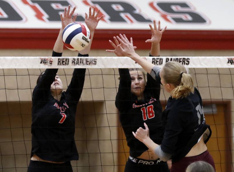 Prairie Ridge's Jada Hoyt (right) hits into the block of Huntley's Jocelyn Erling (left) and Sienna Robertson (center) during a Fox Valley Conference volleyball match on Tuesday, Oct. 8, 2024, at Huntley High School.