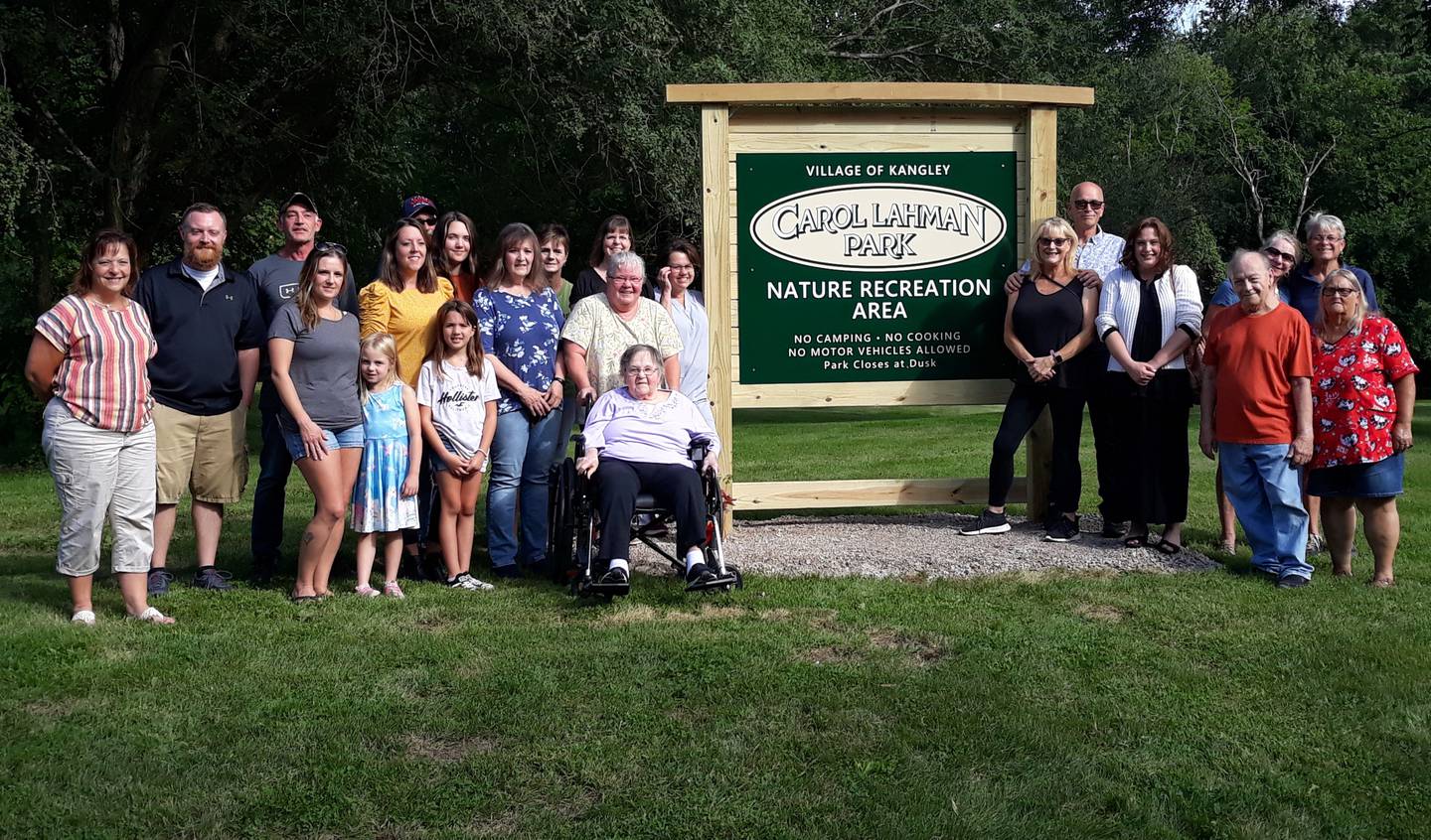 Family and friends of Carol Lahman gather for a photo Thursday, Sept. 1, 2022, around the sign commemorating Kangley's new park named after her.