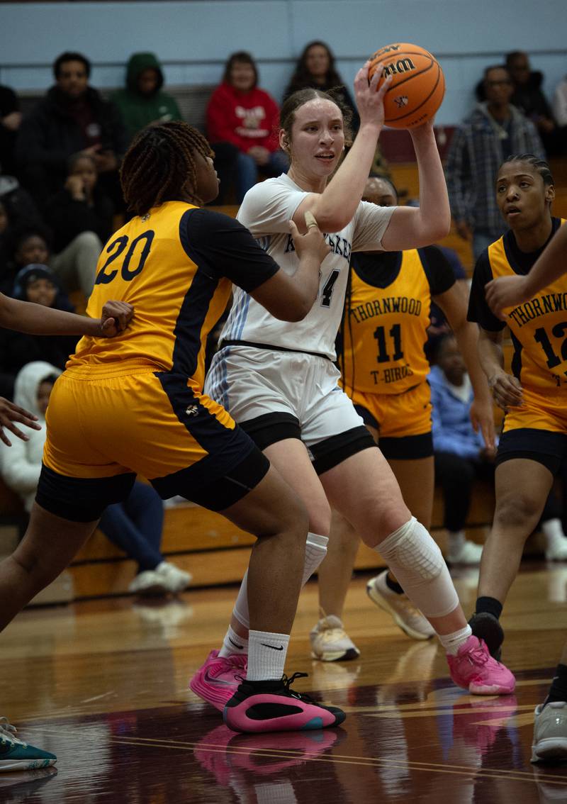 Kankakee's Ava Johnson, center, looks for an open teammate while Thornwood's Joshlyn Williams, left, guards in a game on Thursday, December 11, 2025.