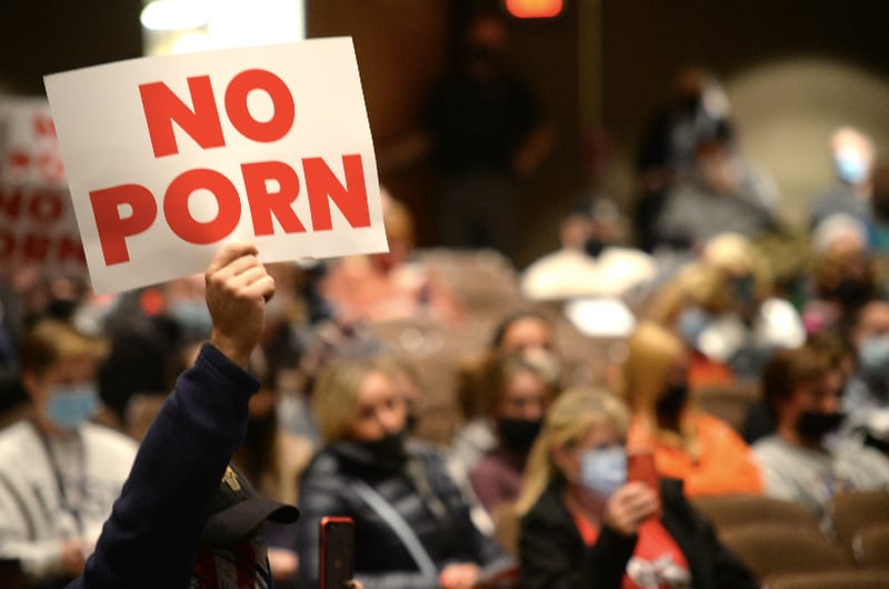 A "No Porn" placard is held up Monday night during the Community High School District 99 school board meeting. The board heard comments from several individuals in support and opposition to including "Gender Queer: A Memoir" in the school libraries. (Photo - Erica Benson)