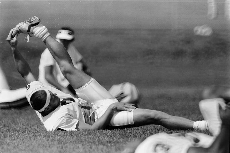 Chicago Bears quarterback Jim McMahon stretches during training camp on Wednesday, June 12, 1985 in Platteville Wis.