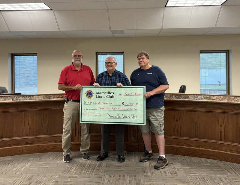 Marseilles Lions Club President Ralph Rowe and First Vice President Jim Hanlon present a $3,500 donation to Mayor Jim Hollenbeck during the City Council meeting Wednesday, completing the club’s $7,000 pledge toward the Broadway Park pavilion.