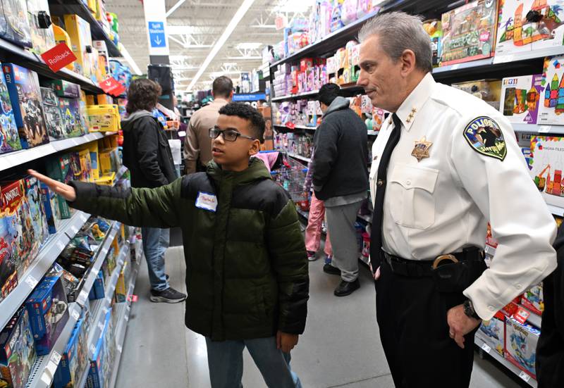 Trenton Walker Jr., 11, of Carpentersville shops with Sleepy Hollow Police Chief Sam Parma during the Dundee Township Shop with a Cop event at Walmart on Saturday, Dec. 14, 2024 in Carpentersville.