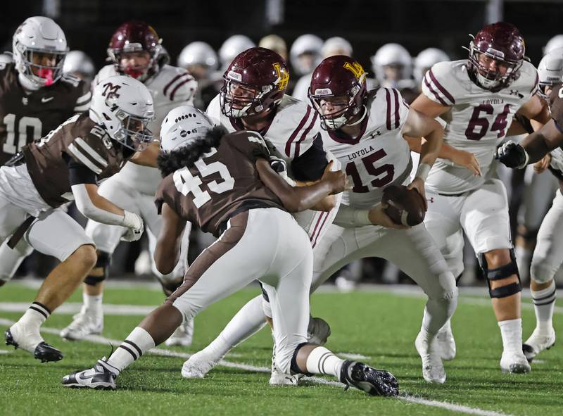 Loyola's Ryan Fitzgerald (15) scrambles after recovering a fumble during the varsity football game between Loyola Academy and Mt. Carmel high school on Friday, Oct. 25, 2024 in Chicago.