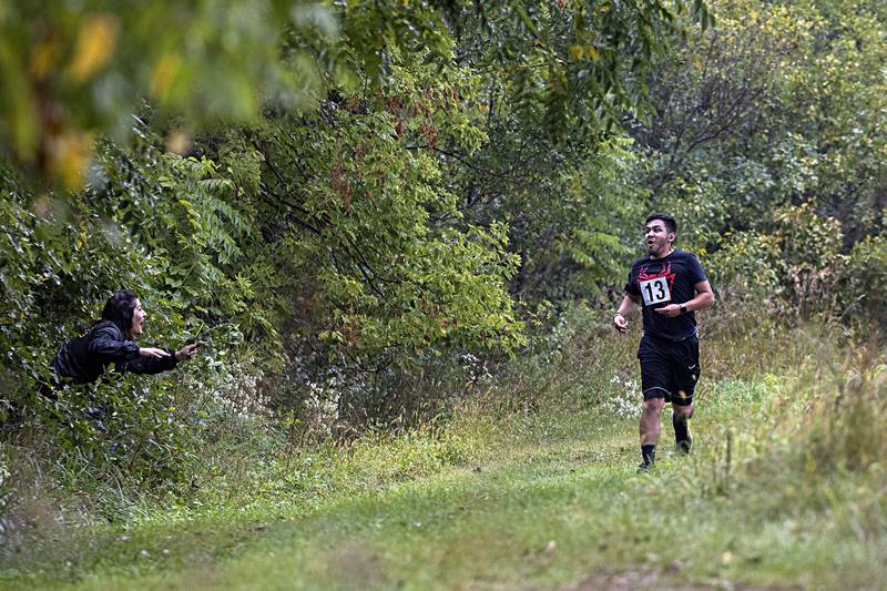 Carlos Rodriguez of Dixon is startled as Jacqueline Como leaps from the bushes Saturday, Sept. 16, 2023 along the Zom-G 5K course.