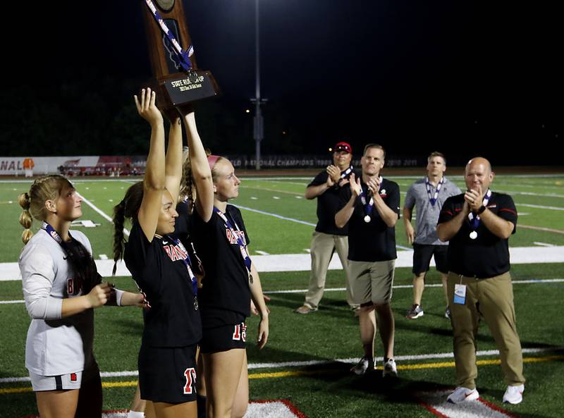 Barrington's Ellie Sanchez and Kate Lubinsky  lift the second-place trophy after Barrington lost to O'Fallon in overtime in the IHSA Class 3A state championship match at North Central College in Naperville on Saturday, June 3, 2023.