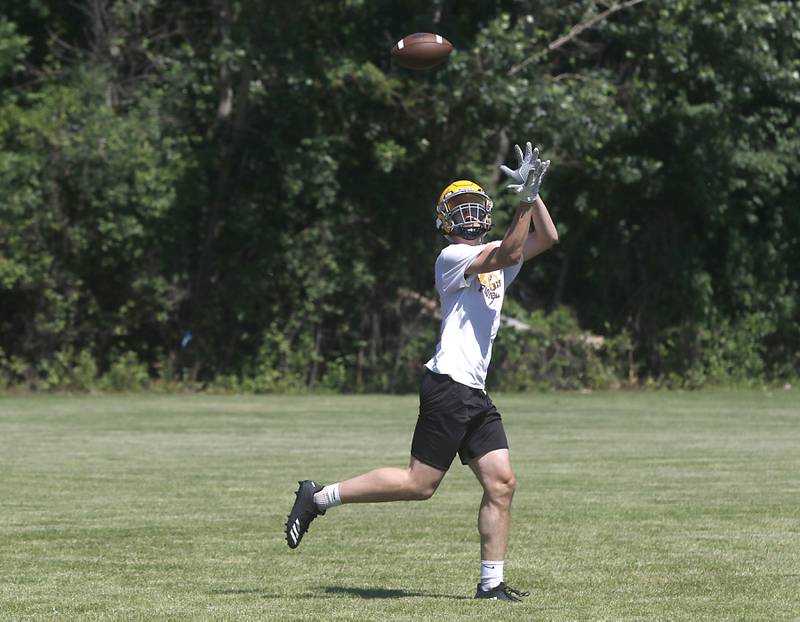 Grant Stec catches the ball during football practice Monday, June 20, 2022, at Jacobs High School in Algonquin.