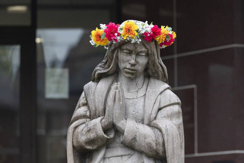 A crown of flowers adorns the head of a statue of the Blessed Virgin Mary on Wednesday, Thursday, May 1, 2025, outside of St. Mary’s School in Dixon. May 1 is observed as a time of devotion to the Blessed Virgin Mary by offering the crown and flowers.