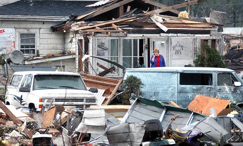 A shocked Helen Lock of Utica sorts through the belongings of her and her neighbors home a day after a massive tornado struck and destroyed much of the small village in central Illinois.