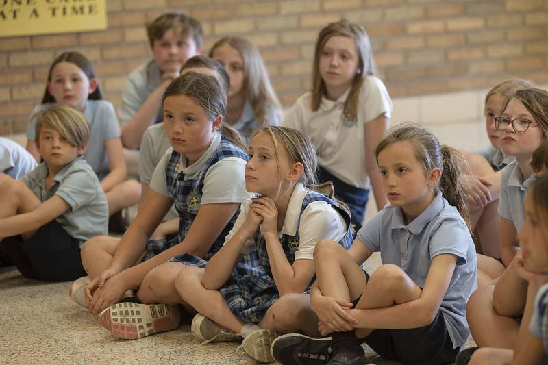 St. Anne’s third, fourth and fifth graders listen as Amanda Donohue reads to them from her book “Tyler’s Purple Arm” on Friday, April 14, 2023. The author also met with the younger classes.