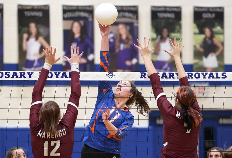 Genoa-Kingston's Lily Mueller tips the ball over two Marengo blockers Thursday, Oct. 27, 2022, during their Class 2A Regional final match at Rosary High School in Aurora.