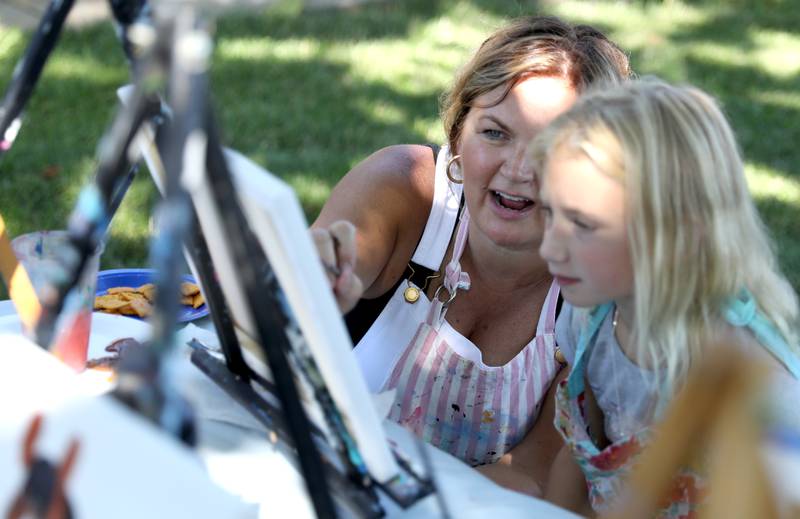 Chelsea McGhee helps Haley Tutt, 7, of Plano with her painting of horses during a painting class at the Little Cottage on the Farm in Kaneville on Thursday, July 27, 2023.