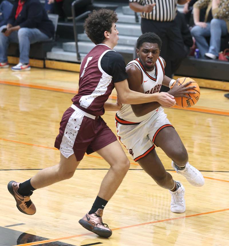 DeKalb's Myles Newman drives against Wheaton Academy's Noah Tink during their game Wednesday, Jan. 14, 2026, at DeKalb High School.
