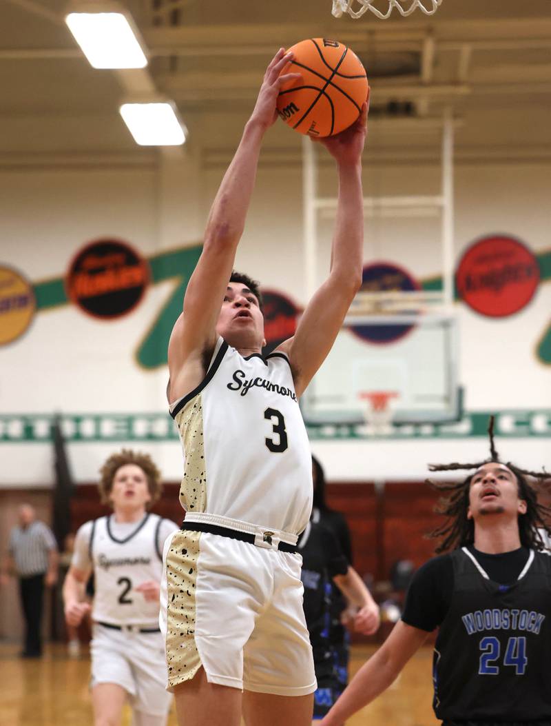 Sycamore's Marcus Johnson gets to the basket ahead of Woodstock's Jeremy Stokes Friday, Feb. 27, 2026, during their IHSA Class 3A boys basketball regional championship game at Boylan Catholic High School in Rockford.