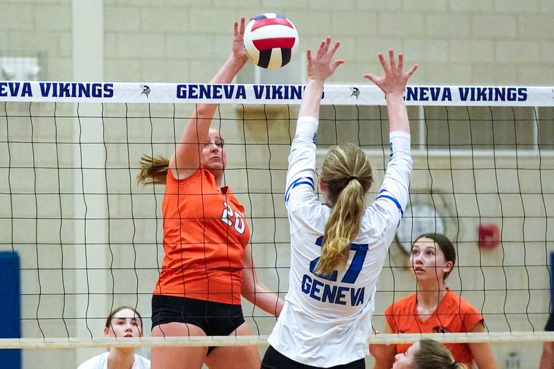 Wheaton Warrenville South's Willow Boecker (20) plays the ball at the net against Geneva’s Molly Franz (27) during a DuKane Conference match in Geneva on Tuesday, Sept. 16, 2025.