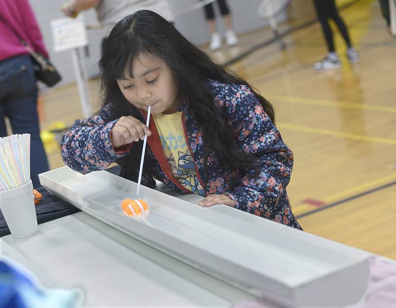 Katherine Gonzalez uses wind power at the Y Aquatics booth to move an object along a water trough Saturday, April 20, 2024, during the Healthy Kids Day at the Streator Y.