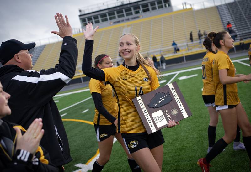 Herscher's Molly Huizenga high-fives assistant coach Alan High, left, after taking the regional championship 8-0 against Bishop McNamara on Tuesday, May 20, 2025.