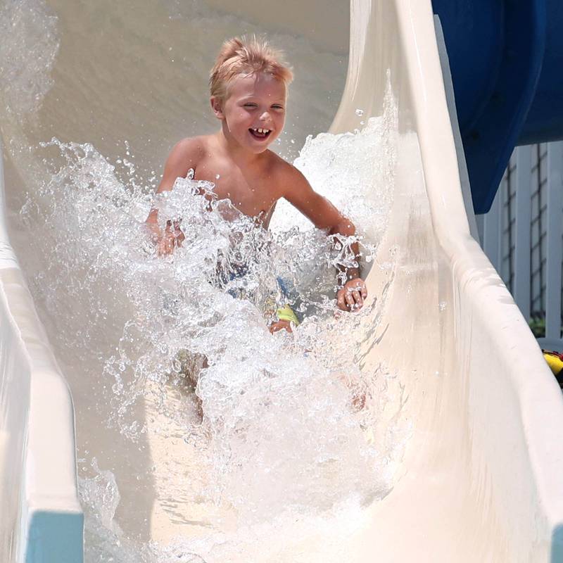 Corbin Campbell, 7, from DeKalb, slides down one of the water slides Tuesday, July 25, 2023, at Hopkins Pool in DeKalb.