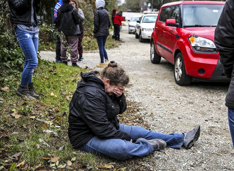 Friends of Kaitlyn Kearns, a 24-year-old bartender from Joliet, cry Thursday, Nov. 16, 2017, along East Washington Street as county investigators search a clubhouse belonging to the Outlaws Motorcycle Gang in Joliet, Ill. Kearns' body was found Thursday in a rural area of Kankakee County, according to a sheriff’s office news release.