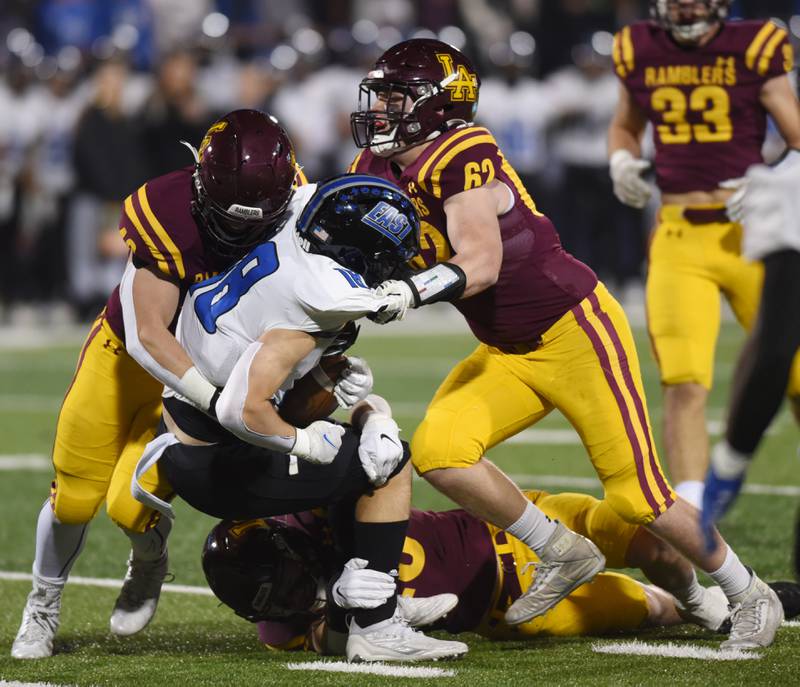 Loyola Academy’s Colin Scheid, left, and Jack Wetoska, right, tackle Lincoln-Way East's Jimmy Curtin during the Class 8A football state title game at Memorial Stadium in Champaign on Saturday, Nov. 26, 2022.