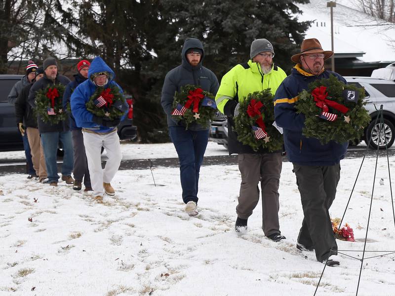 Veterans prepare to lay ceremonial wreaths that represent each military branch at St. Gall’s Cemetery in Elburn on Saturday, Dec. 17, 2022.