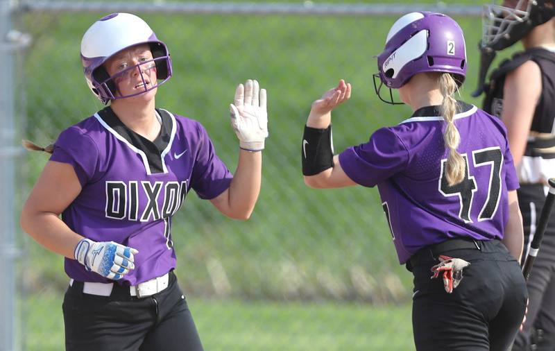 Dixon's Sam Tourtillott is congratulated by teammate Anna Kate Phillips after driving in a run during their game against Sycamore Thursday, May 12, 2022, at Sycamore High School.