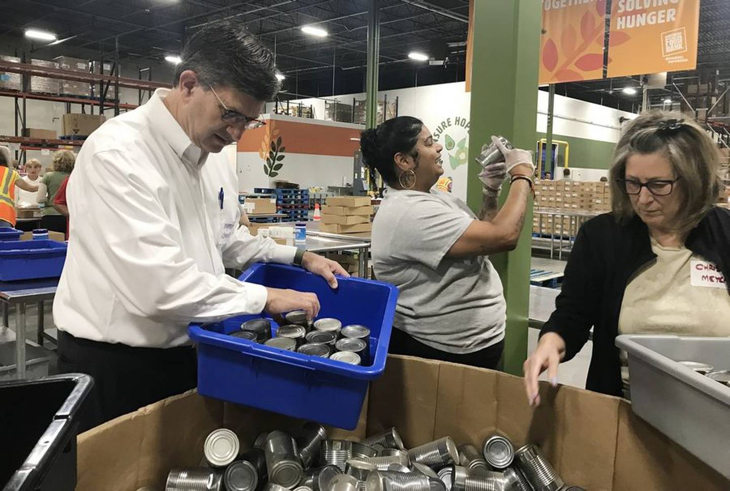 U.S. Rep. Brad Schneider, left, learns about food sorting Wednesday, Aug. 16, 2023, at the Northern Illinois Food Bank's north suburban distribution center in Lake Forest. Schneider secured $750,000 in funding for the new, expanded facility celebrating its anniversary.