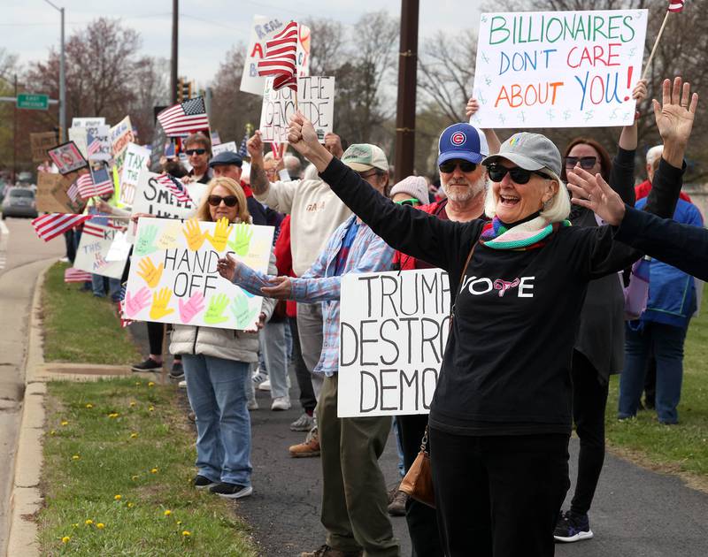 Protesters demonstrate along Sycamore Road in front of Hopkins Park Saturday, April 19, 2025, during a “No Kings” rally and march in DeKalb. The group was protesting what they’ve argued is the unlawful and harmful federal policies of President Donald Trump and his administration.