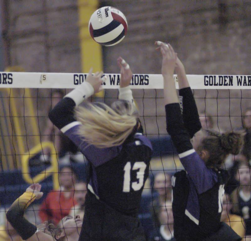 The ball is blocked by two Dixon defenders. Sterling hosted Dixon in Volleyball on August 26, 2025 at Musgrove Fieldhouse.