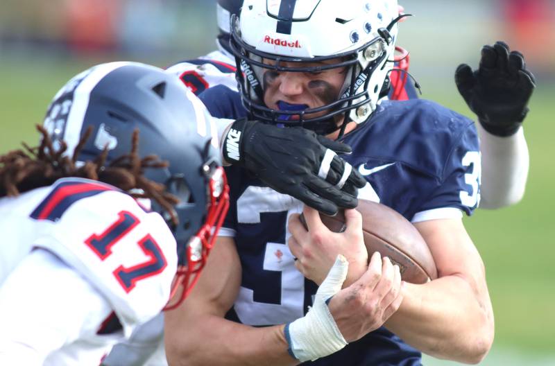 Cary-Grove’s Holden Boone tries to shake off Belvidere North defenders in IHSA Class 6A quarterfinal playoff football action on Saturday, Nov. 16, 2024, at Al Bohrer Field on the campus of Cary-Grove High School in Cary.