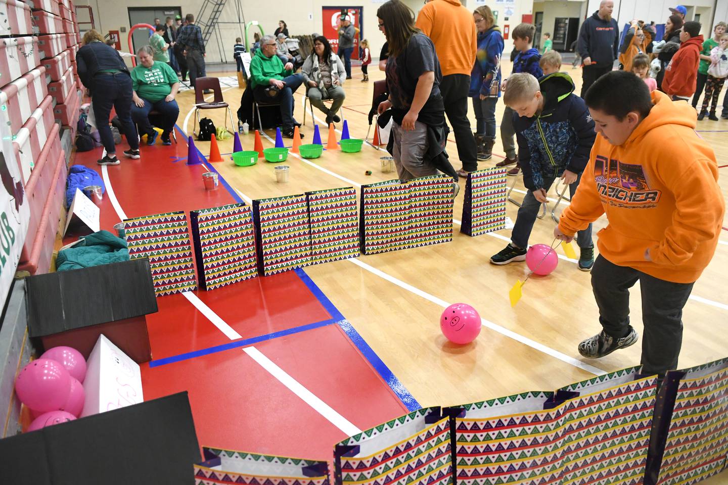 Connor Clark, 8, of Rochelle and David Bagwell, 10, of the Leaf River Soaring Eagles 4-H Club herd balloon pigs into their pen with fly swatters at the 4-H Penny Carnival on Saturday, March 18.