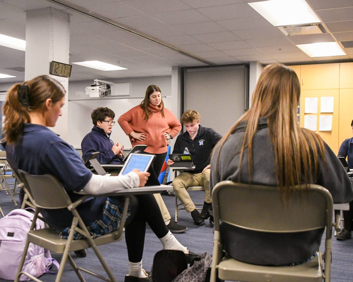 Nazareth Academy theater student Max Megrete, second from left, reads a line during the first read of a play as theater director Aileen O’Carroll looks over the shoulder of Sebastian Wagner during theater class at Nazareth Academy High School in La Grange Park on Monday Jan. 22, 2024.