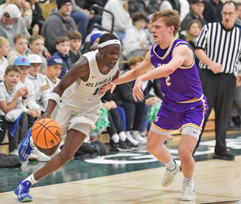 Glenbard West’s Josh Abushanab (left) drives past Downers Grove North’s Jack Romsey during a game on January 23, 2026 at Glenbard West High School in Glen Ellyn.