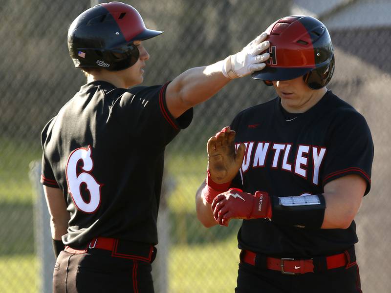 Huntley’s Joey Garlin gives his teammate,  Ryan Bakes a tap on the helmet after Bakes hit a home run during a Fox Valley Conference baseball game against Prairie Ridge Wednesday, April 12, 2023, at Prairie Ridge High School.