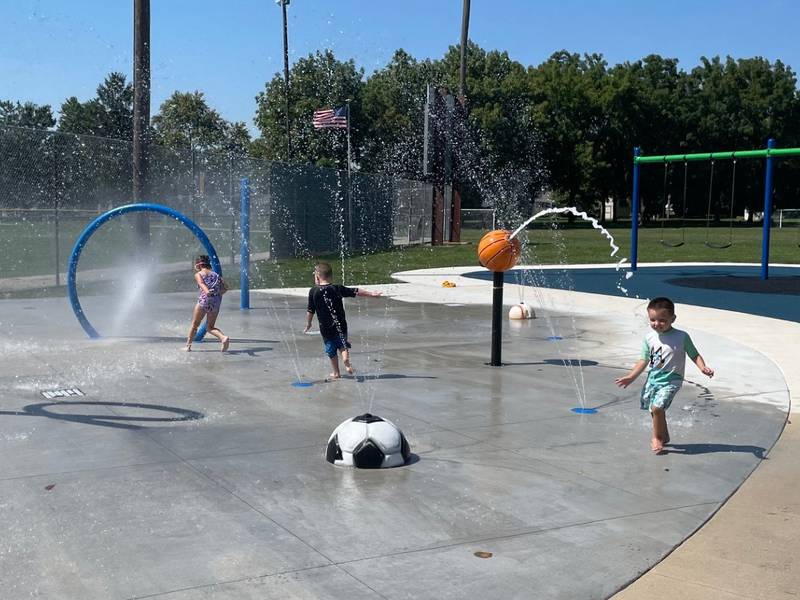 Mackenzie Roetker (from left), 6, Hudson Thomas, 3, and Elliott Roetker, 3, all of Ottawa, enjoy the soft opening Sunday, Sept. 1, 2024, of the new Peck Park Playground and Splash Pad in Ottawa. The park will be closed Sept. 3 and Sept. 4 for some finishing touches before the grand opening and ribbon cutting at 10 a.m. Thursday, Sept. 5.