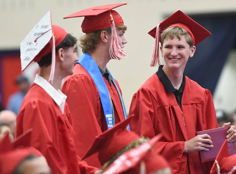 Oregon High School graduates Benny Olalde, Tucker O'Brien and Noah Near chat during the Class of 2026 commencement ceremony on Sunday, May 24, 2026 at the Blackhawk Center in Oregon.