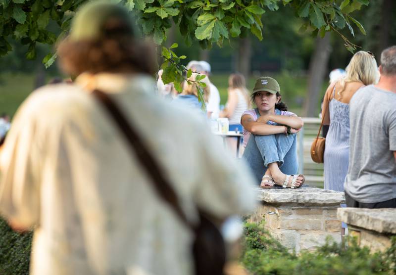 Musician Demi Clara of Plainfield watches her boyfriend Aaron Kelly perform during Thirsty Thursday on the Deck at the Lake Ellyn Boathouse in Glen Ellyn on July 20, 2023.