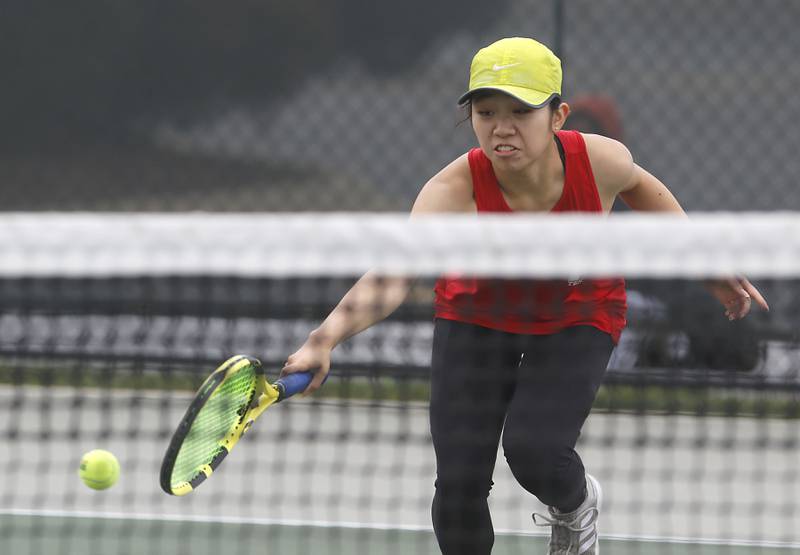 Napervile Central’s Kira Yang tries to hit the ball over the net hursday, Oct. 19, 2023, during doubles match on the first day of the IHSA State Girls Tennis Tournament at Hoffman Estates High School in Hoffman Estates.