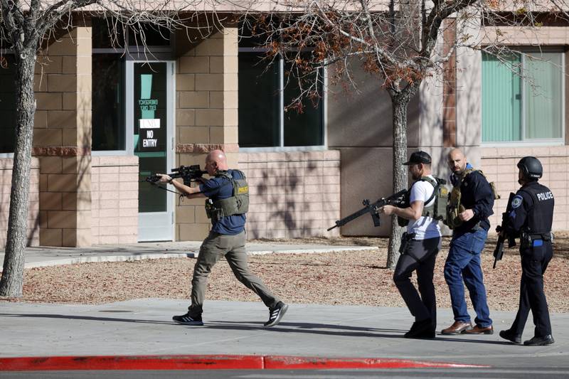 Law enforcement officers head into the University of Nevada, Las Vegas, campus after reports of an active shooter, Wednesday, Dec. 6, 2023, in Las Vegas.