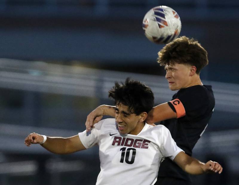 McHenry's Keegan Adamson (right) heads the ball away from Prairie Ridge's Mateo Torres during a Fox Valley Conference boys soccer match on Tuesday, Sept. 30, 2025, at McCracken Field in McHenry.