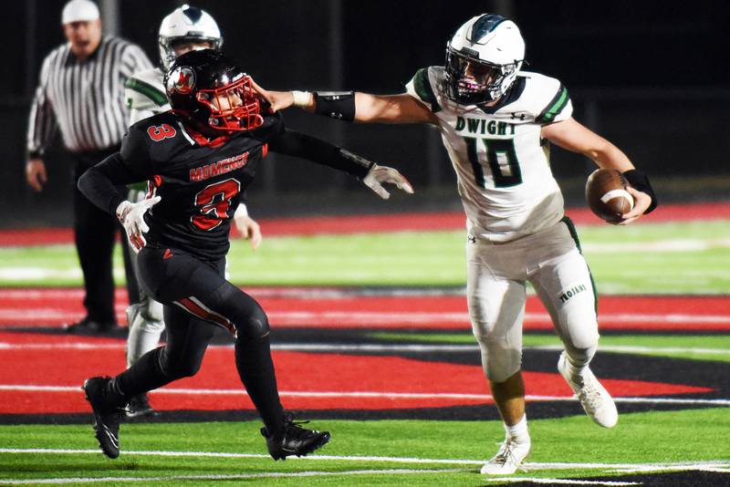Dwight/Gardner-South Wilmington's Evan Cox (10) stiff-arms Momence's Eddie Ferreira during Friday's first-round game of the IHSA Class 2A playoffs in Momence. The Trojans scored their first playoff victory since 1983 with a 41-13 win.