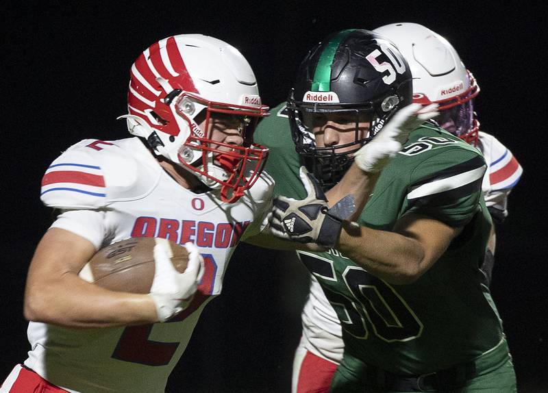 Oregon’s Cooper Johnson fights through a Rock Falls tackler Friday, October 11, 2024, in Rock Falls.