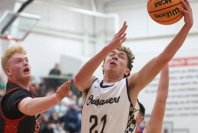 Marquette's Lucas Craig runs to the hoop around Indian Creek's Isaac Willis during the Class 1A Sectional game on Friday, March 6, 2026 at Amboy High School.