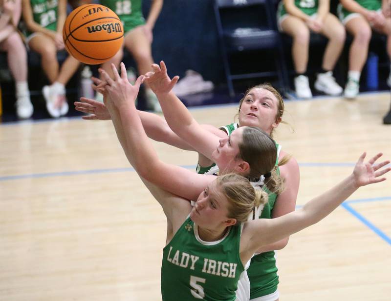 Marquette's Kelsey Cuchra (middle) is fouled underneath the hoop by Seneca's Lauryn Barla (bottom) as teammate Tessa Krull (top) looks to hit the ball away on Thursday, Dec. 5, 2024 in Bader Gym at Marquette High School.