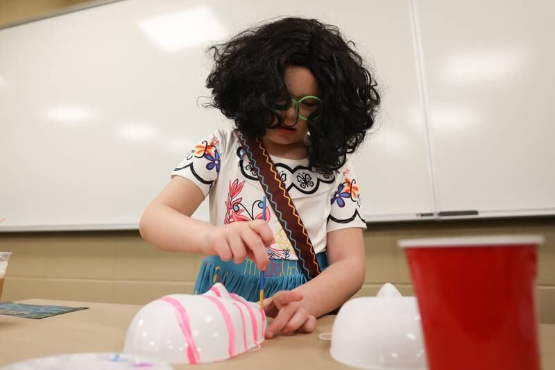 Quinn Bredesen, 8, form Crest Hill paints a mask at the STEAM Spooktacular hosted by the After the Peanut Foundation on Wednesday at Lewis University.