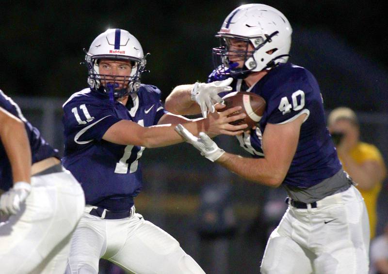 Cary-Grove’s Peyton Seaburg hands off to Logan Abrams against Jacobs in varsity football on Friday, Sept. 20, 2024, at Al Bohrer Field on the campus of Cary-Grove High School in Cary.