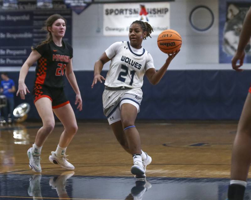Oswego East's Desiree Merritt (21) passes the ball on a drive down the lane during their basketball game between Minooka at Oswego East Friday, Jan 16, 2026 in Oswego.