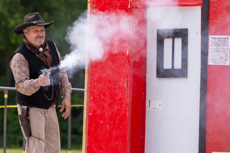 An actor from the Old West Regulators group fires a shot during the reenactment of the life of Wild Bill Hickok behind the LaSalle County Historical Museum during Wild Bill Days on May 31, 2025.